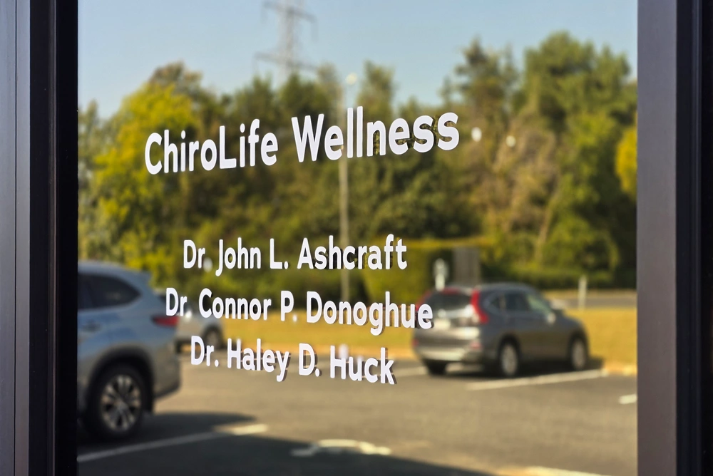 Exterior window signage listing ChiroLife Wellness and clinic doctors.